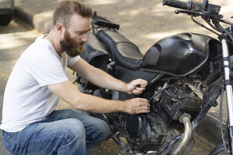 Hombre arreglando su moto para venderla